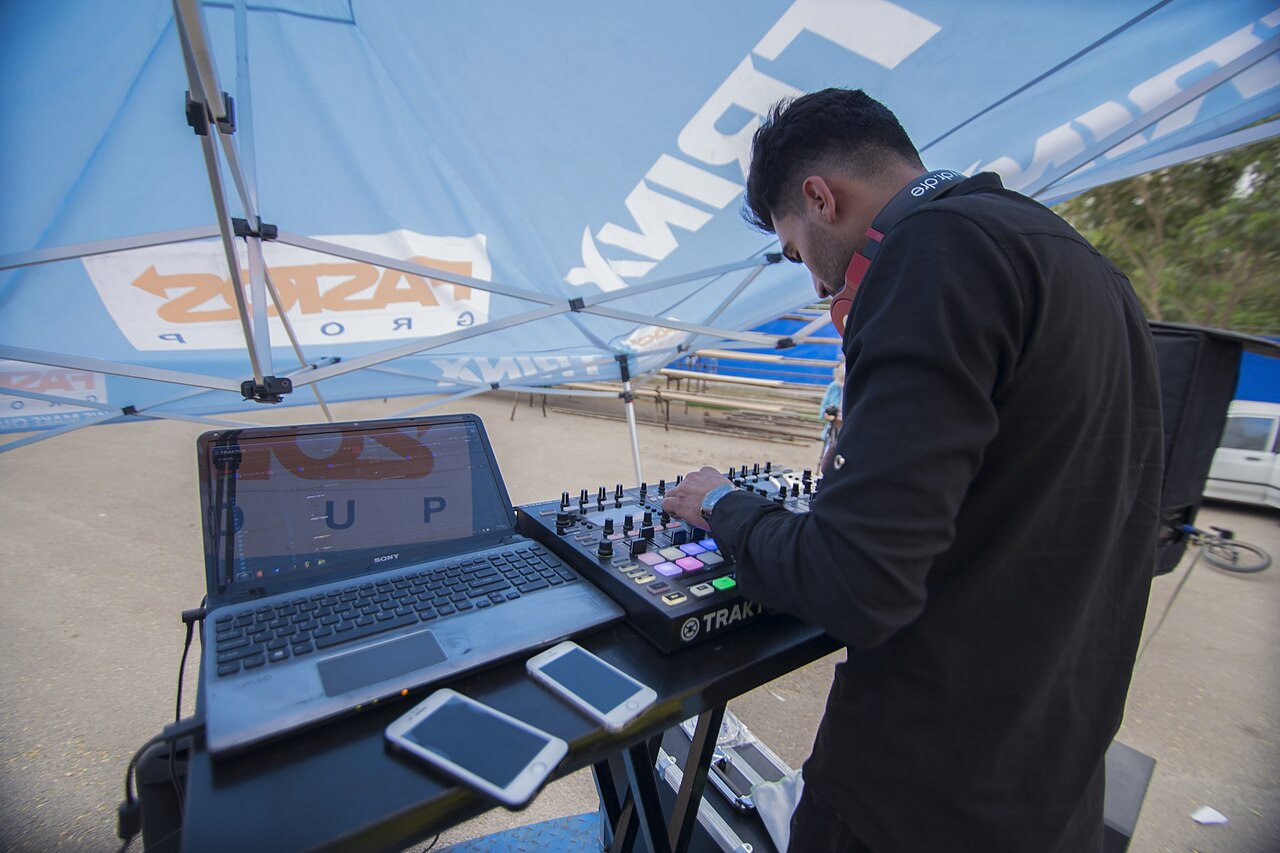 Performer using a laptop and audio equipment outdoors