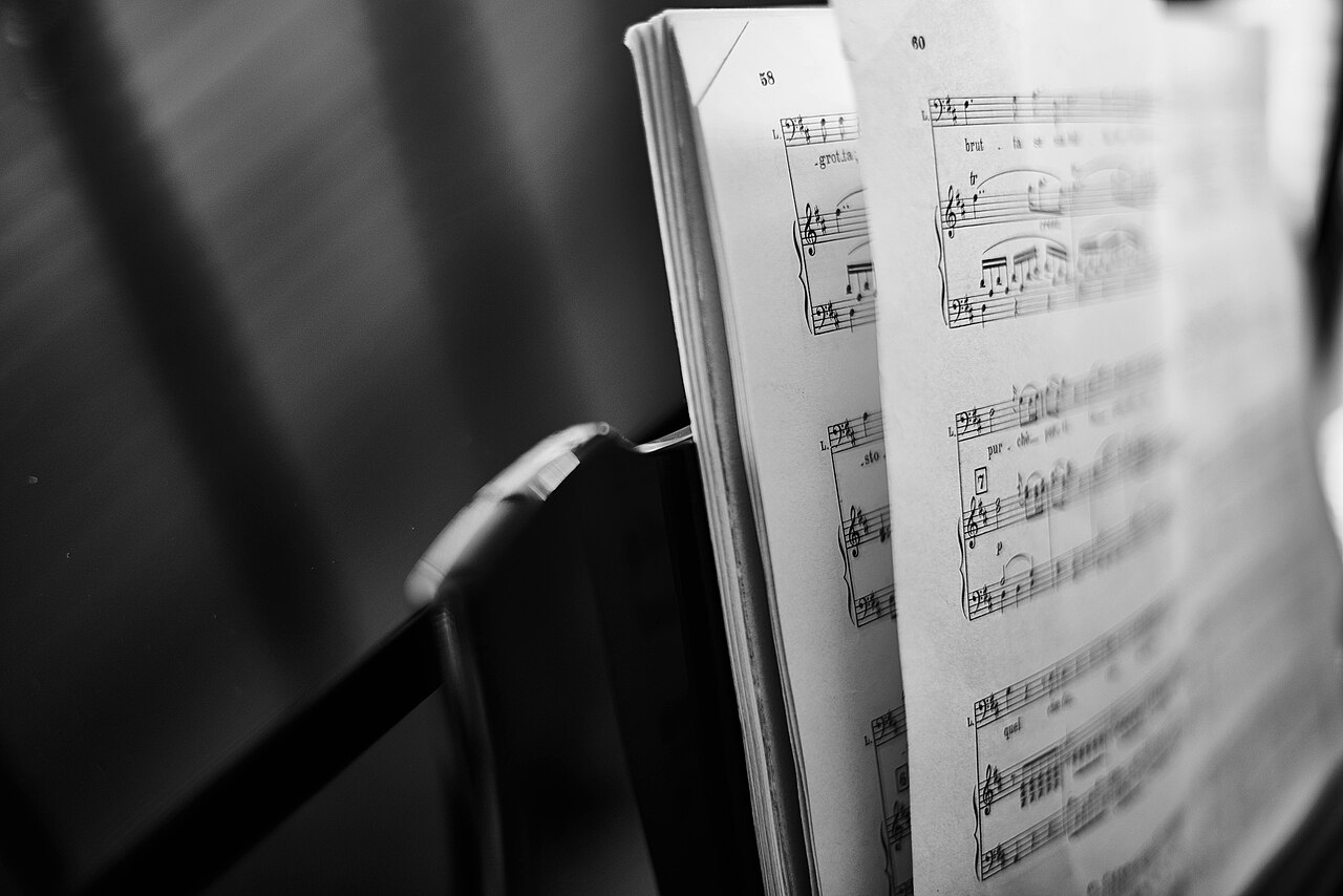 Open sheet music beside a musical instrument