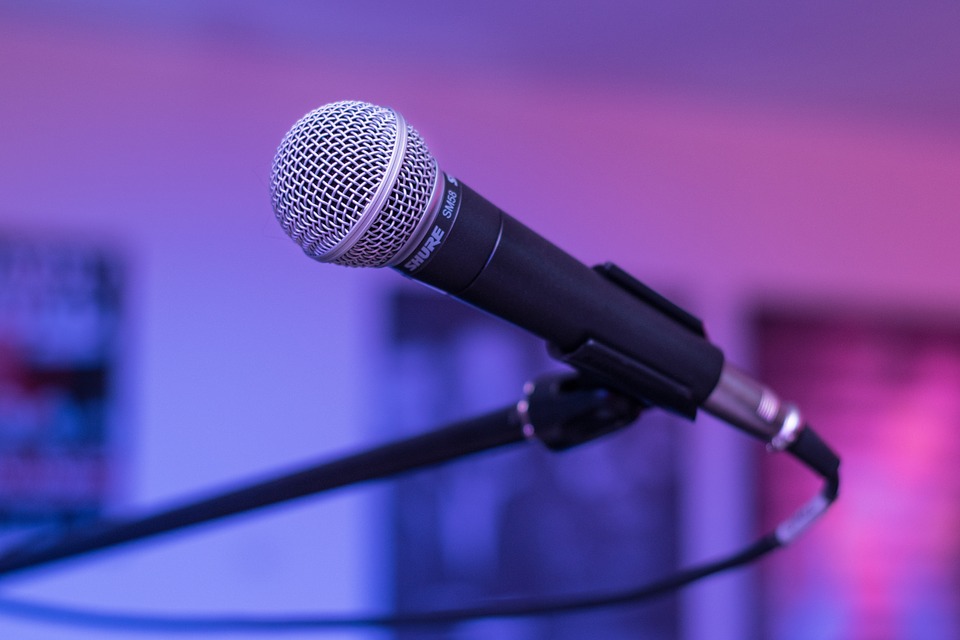 Dynamic vocal microphone on a stand under purple lighting