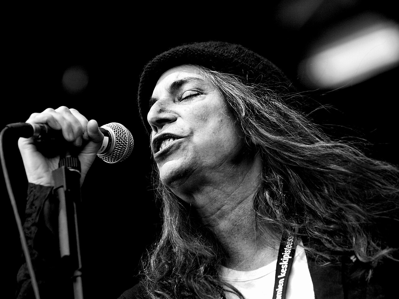 Vocalist singing into a handheld microphone during a concert